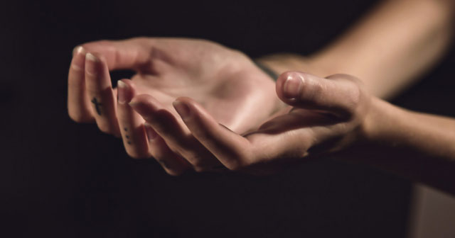 Open hands cupped together in soft light, symbolizing healing energy and transformation through hypnosis.