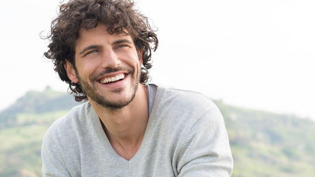 Smiling man outdoors feeling confident and relaxed after hypnosis session