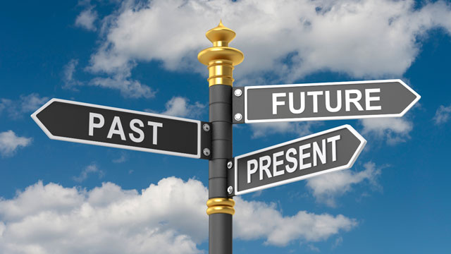 Street sign with arrows pointing to past, present, and future under a blue sky, symbolizing choice and life direction